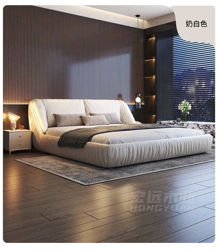 Modern cream upholstered king size bed with a soft, rounded contemporary design in a stylish bedroom setting.
