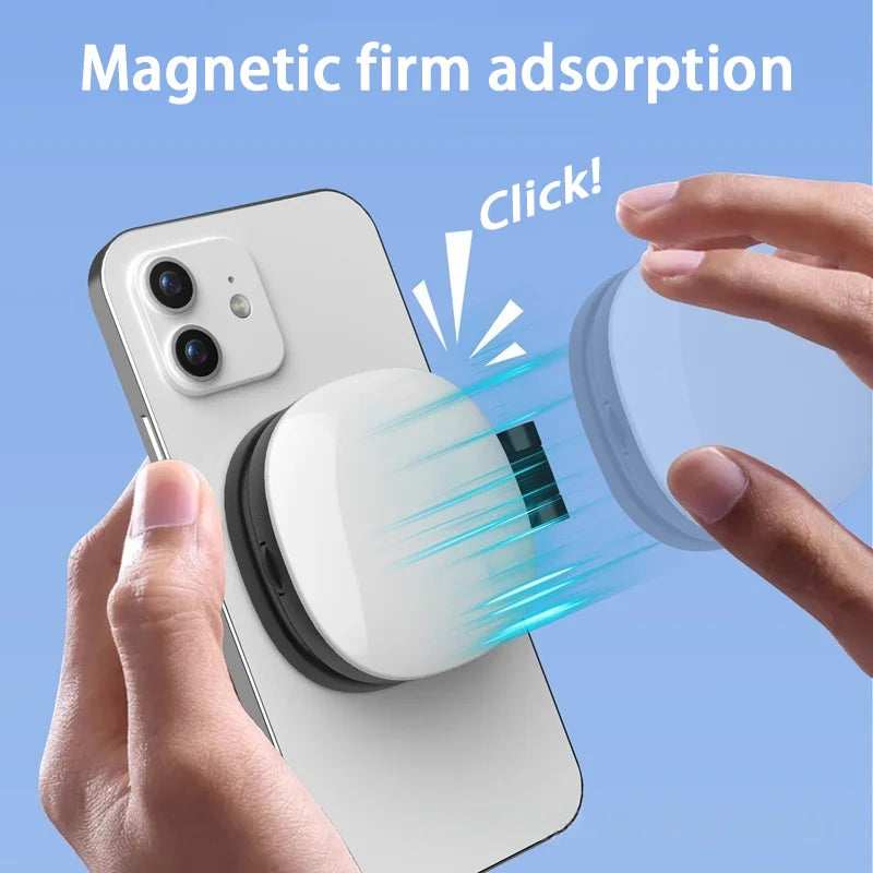 Hands attaching a white, compact magnetic power bank to the back of a white smartphone with a secure click.