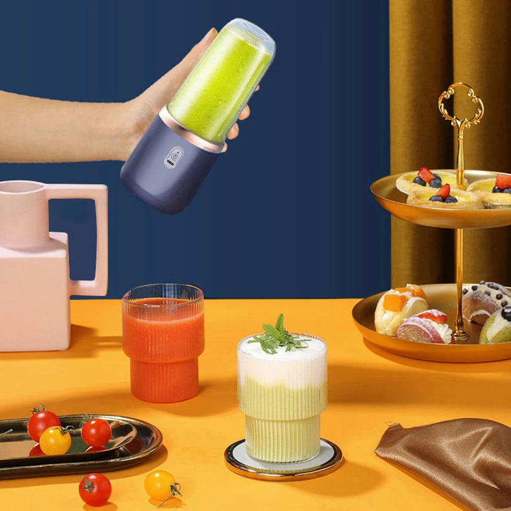 A hand holds a portable, matte navy electric blender containing a green smoothie. Minimalist design with gold trim.