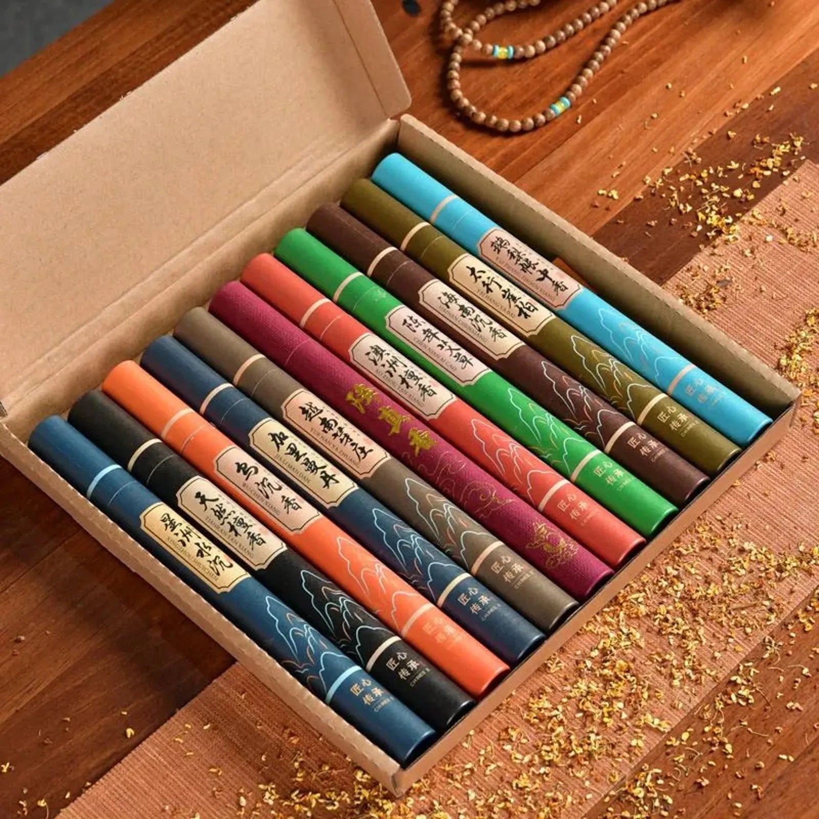 Gift box containing ten assorted colourful tubes of incense sticks with traditional oriental design labels.