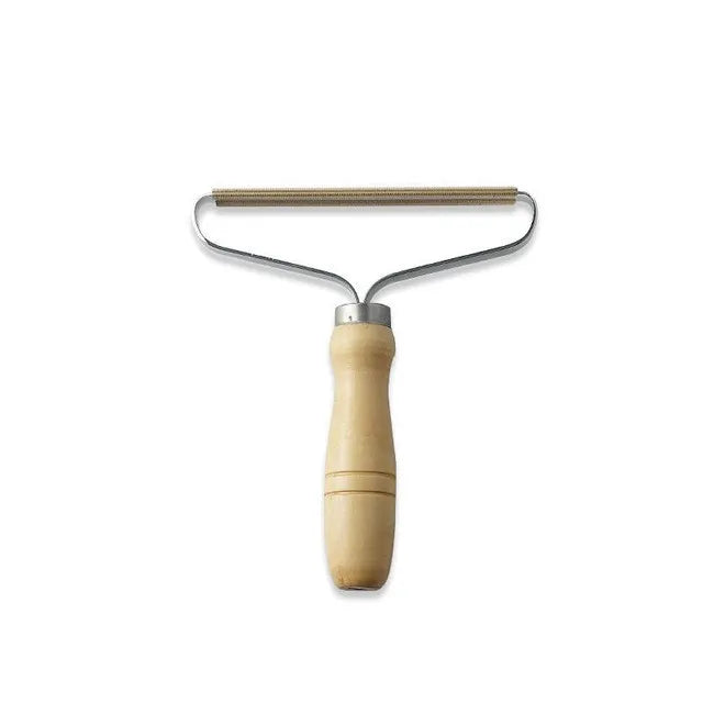 Fabric bobble remover with a light wood handle and a copper-edged metal scraper head.