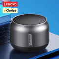 Compact, metallic grey wireless speaker with a circular top-mounted mesh grille, resting on a laptop.