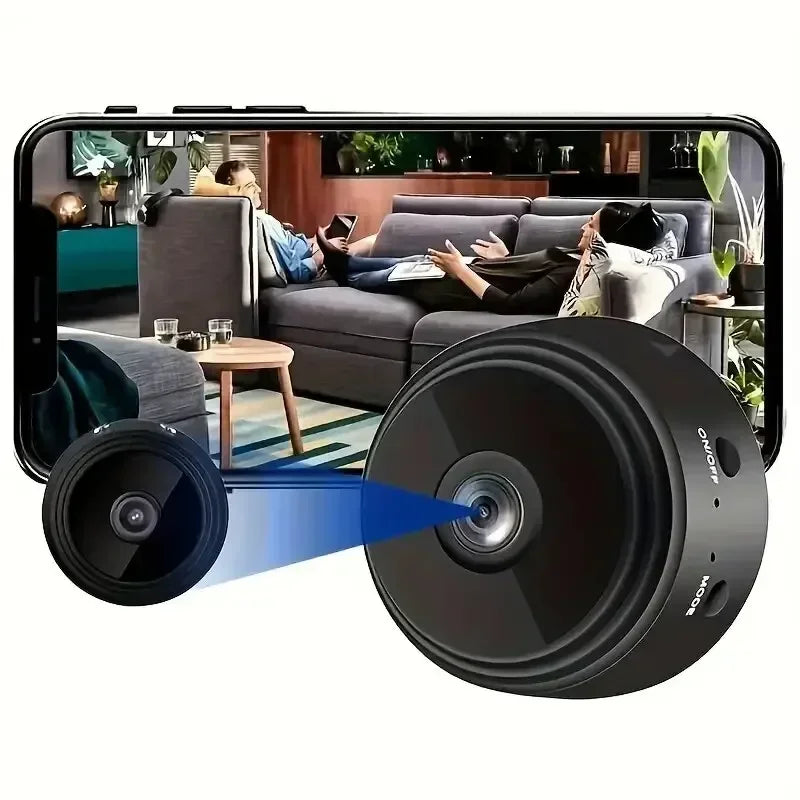 Small black circular plastic wireless security camera with lens and side buttons, displaying video on a smartphone.