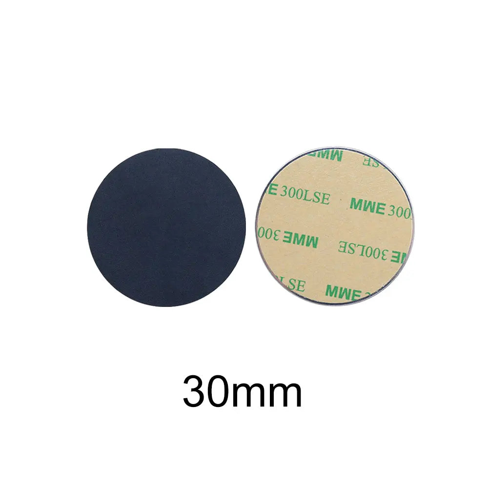 Two 30mm round black adhesive pads, shown from front and back with protective backing paper.