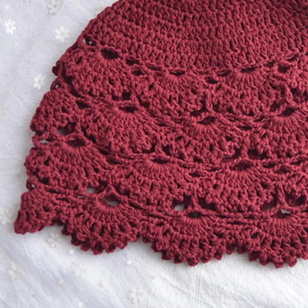 Burgundy women’s crochet hat featuring a delicate hollow lace design with a decorative scalloped edge.