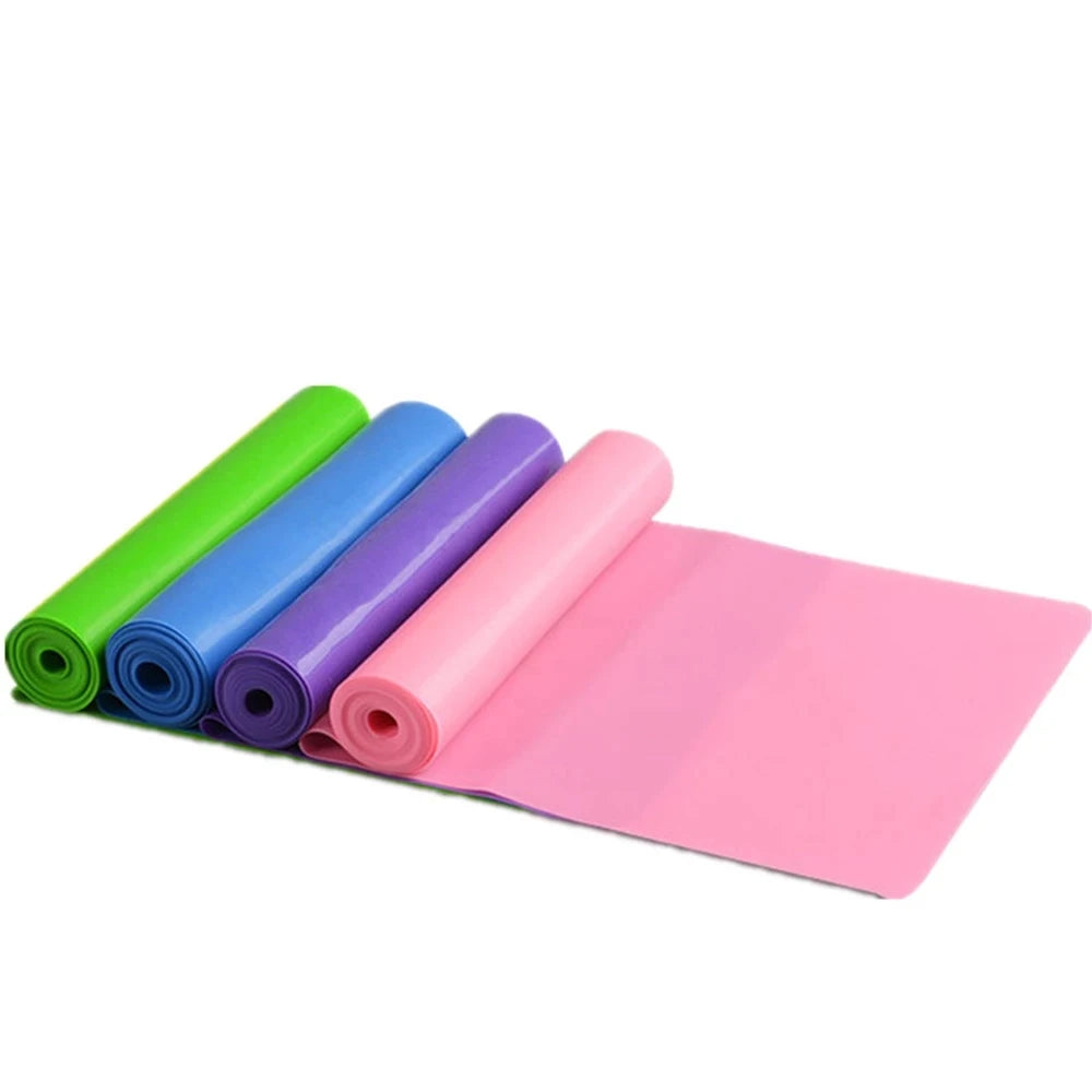 Four rolled, colourful resistance exercise bands in green, blue, purple, and pink, with one band partially unrolled.