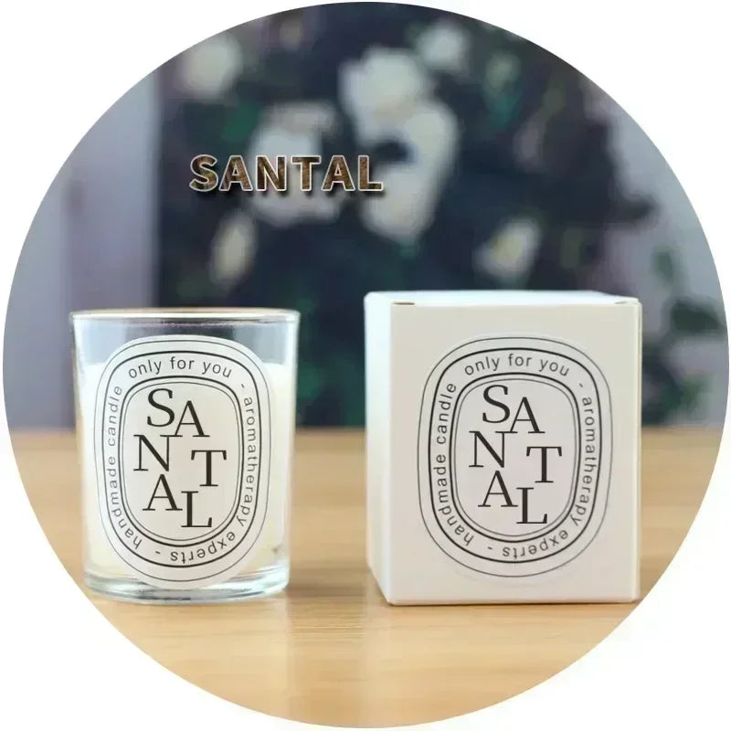 Santal aromatherapy candle in a clear glass jar with matching white box, featuring black oval label design.
