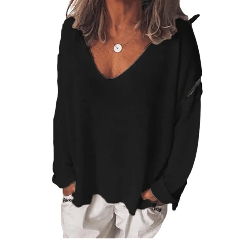 A woman wearing a casual black, long-sleeved V-neck jumper with a relaxed fit.