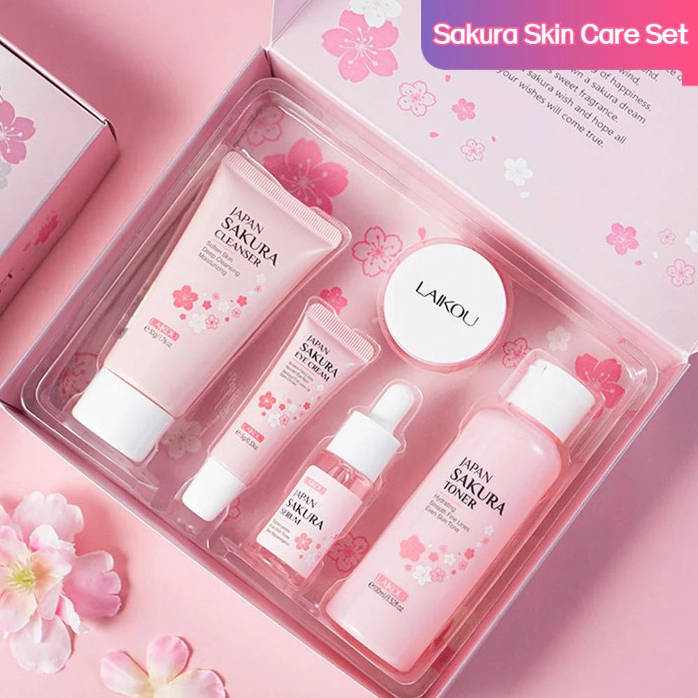 Sakura-themed pink skincare gift set featuring cleanser, eye cream, serum, cream, and toner in a matching floral box.