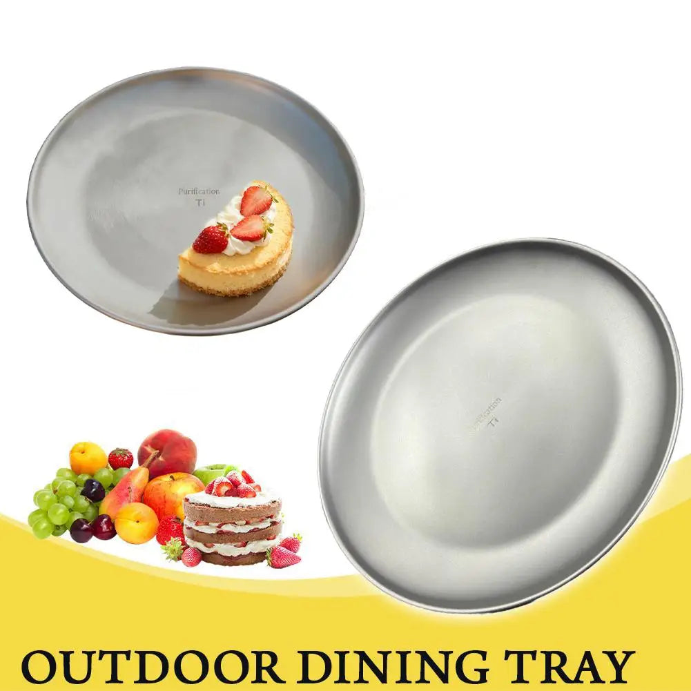 Two round, grey outdoor dining trays with a piece of cake and fruit displayed nearby.