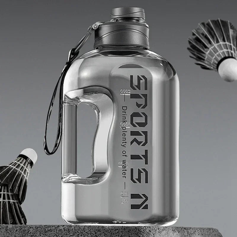 Clear sports water bottle with a grey screw lid, integrated handle, carrying strap, and 'SPORTS' text on the front.