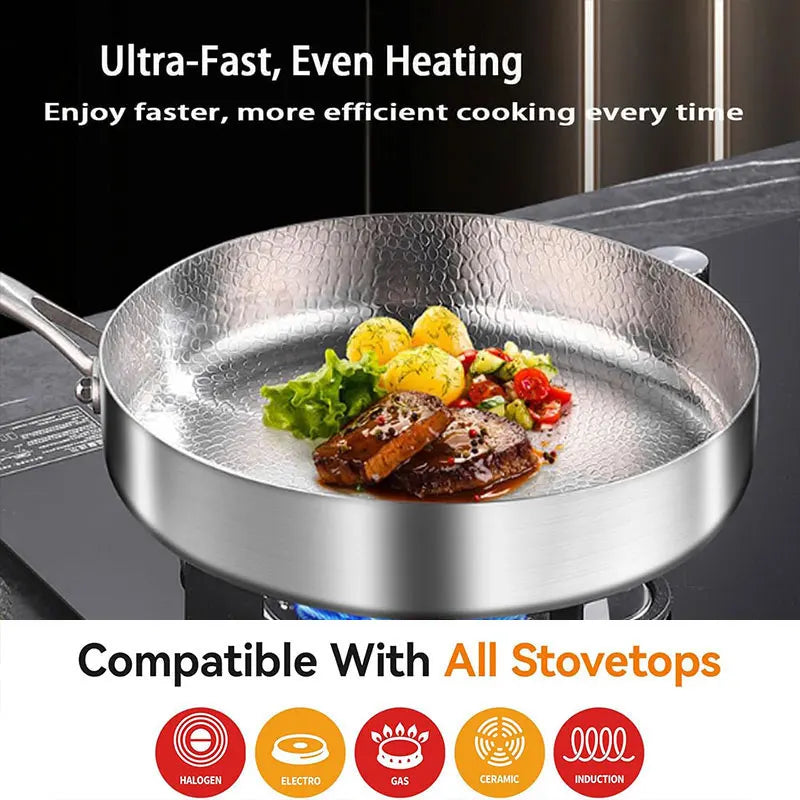 A hammered stainless steel skillet containing cooked meat, potatoes, and vegetables on a stovetop.