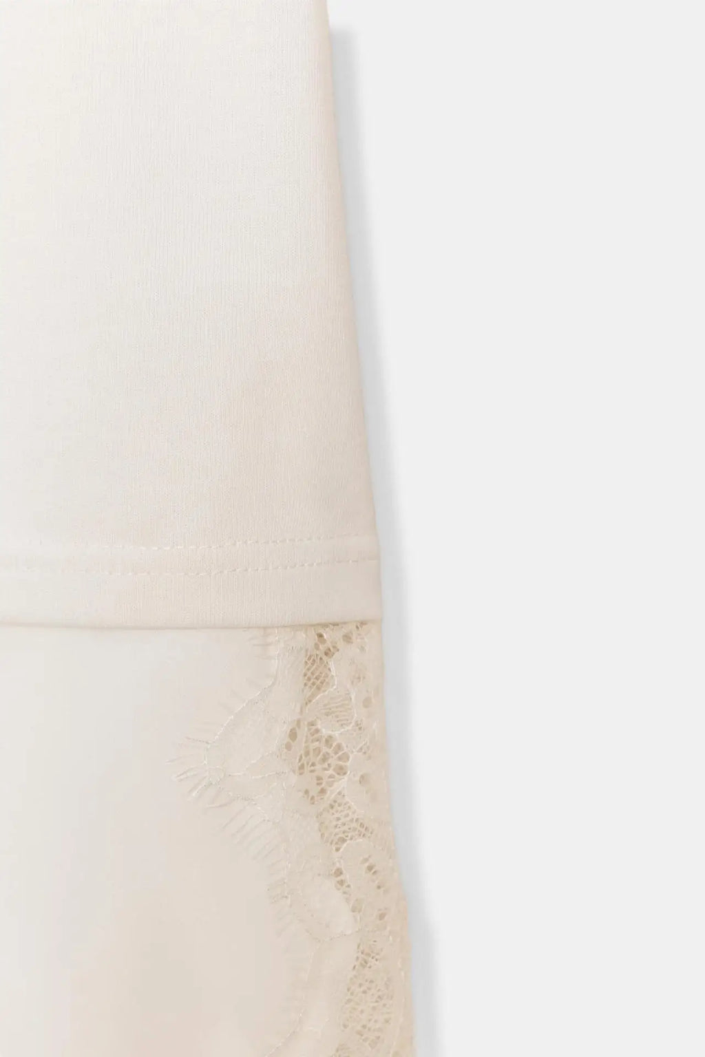 Cream-coloured top featuring delicate floral lace trim detail at the hem.