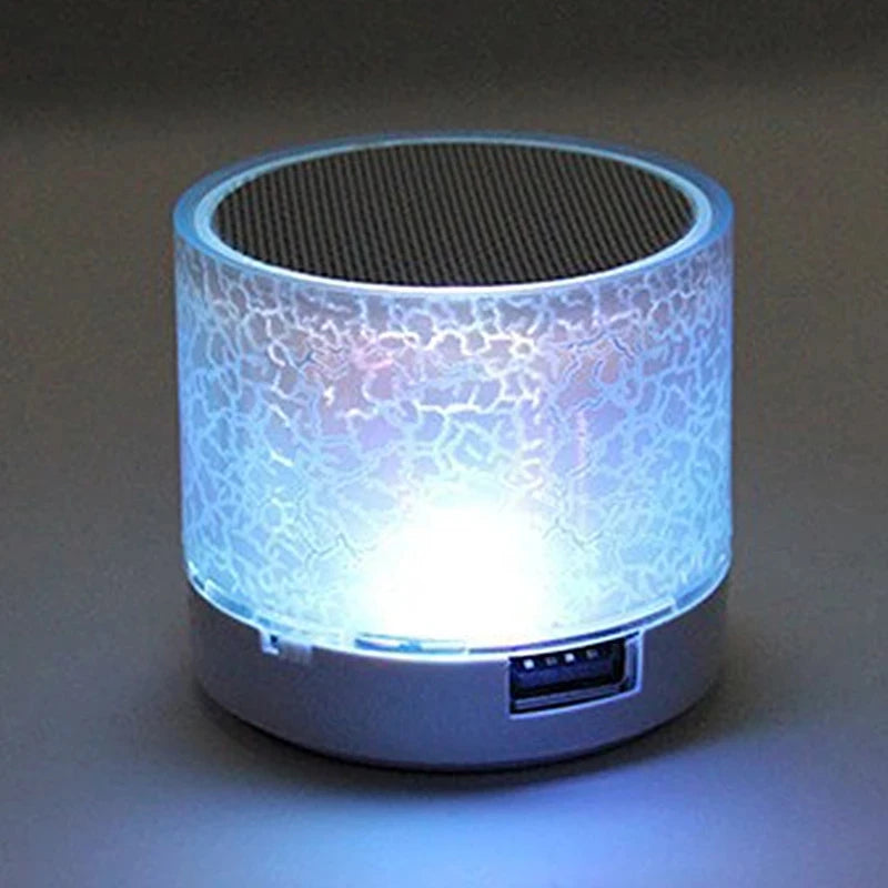 Mini portable Bluetooth speaker in white with a crackled glass effect and glowing internal LED light.