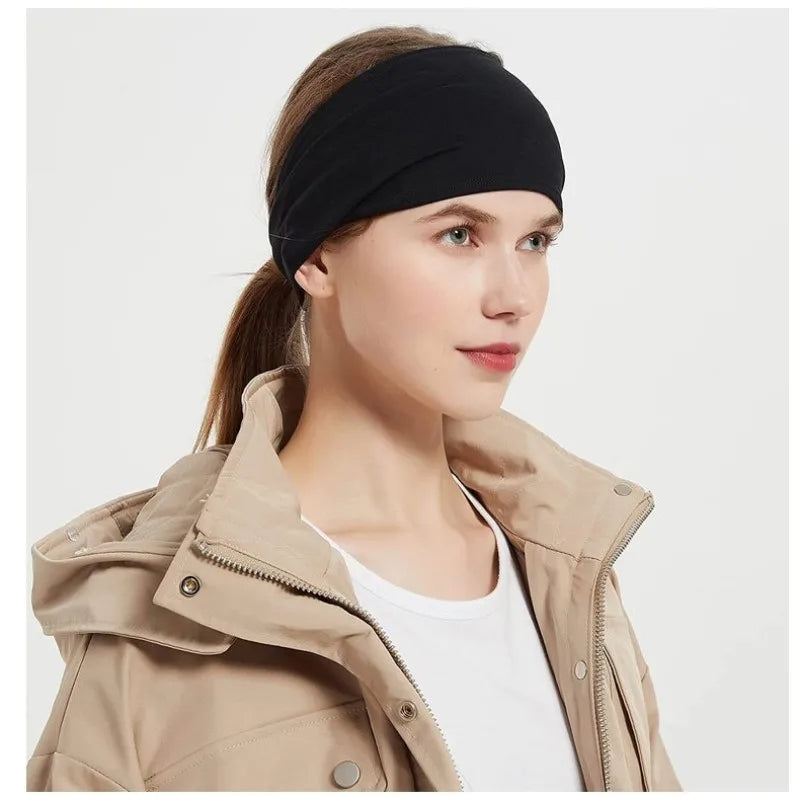 A woman wearing a plain, wide black fabric headband over her hair.