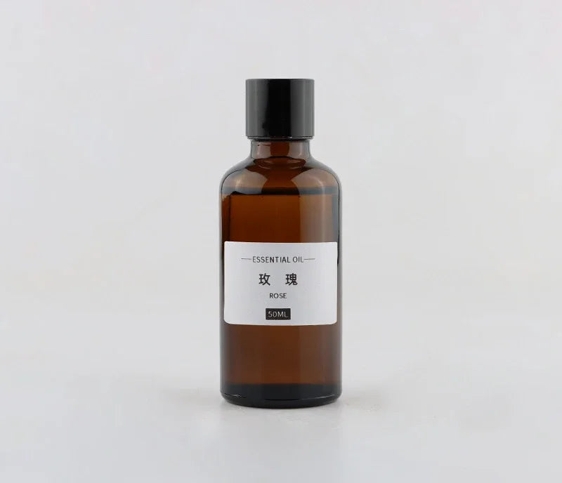 50ml amber glass bottle of rose essential oil with a black screw cap and minimalist white label.