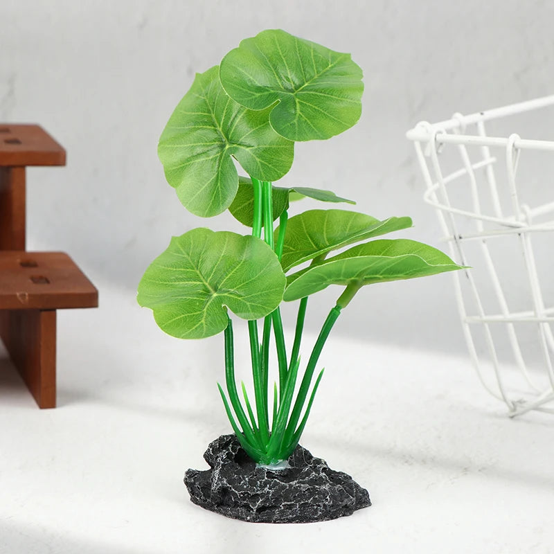 Artificial green plant with broad, heart-shaped leaves on sturdy stems anchored to a textured, dark gray rock base.