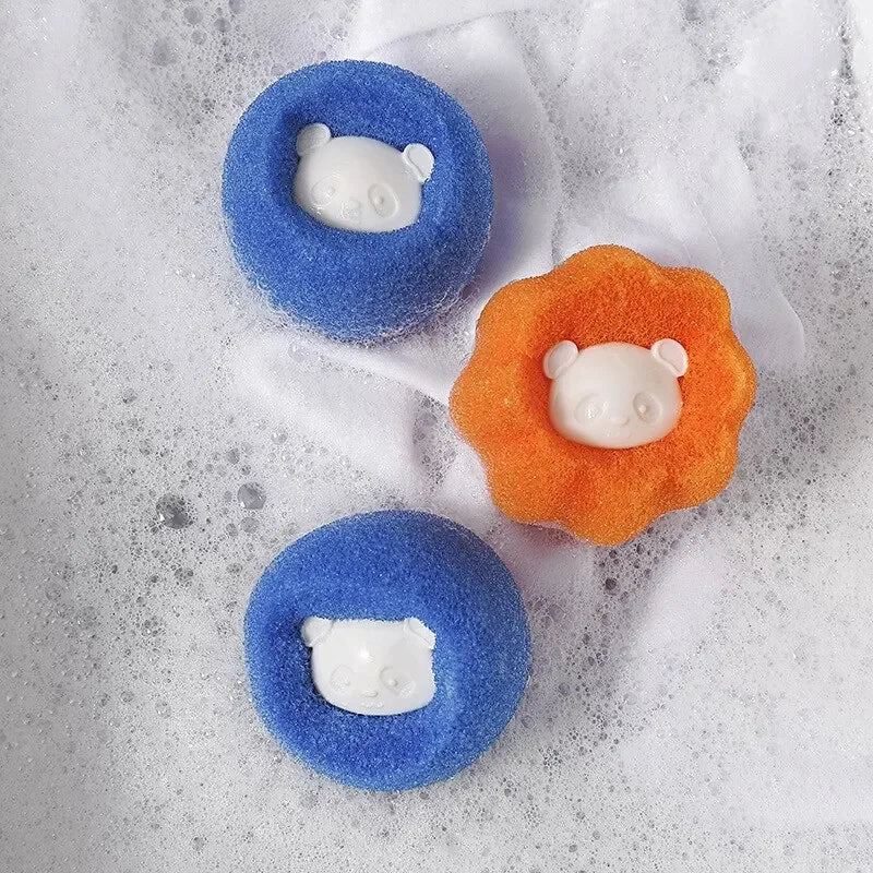 Two blue and one orange sponge bath bombs with white panda faces, resting in a soapy bubble bath.
