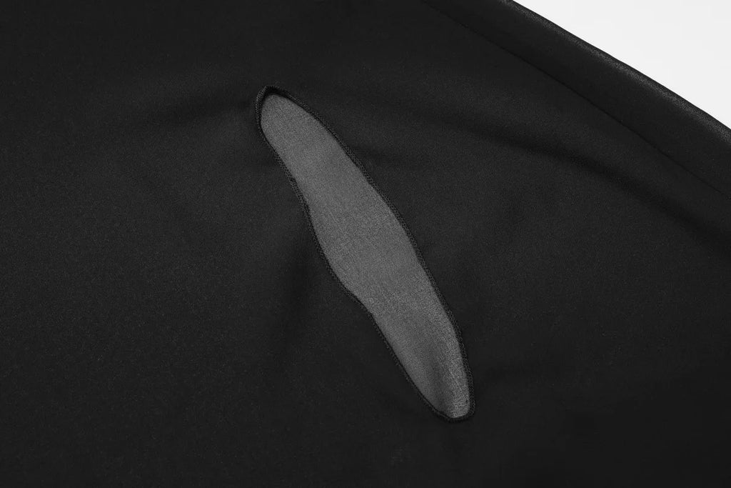 Close-up of black fabric with a sleek, vertical cutout detail and stitched edges.