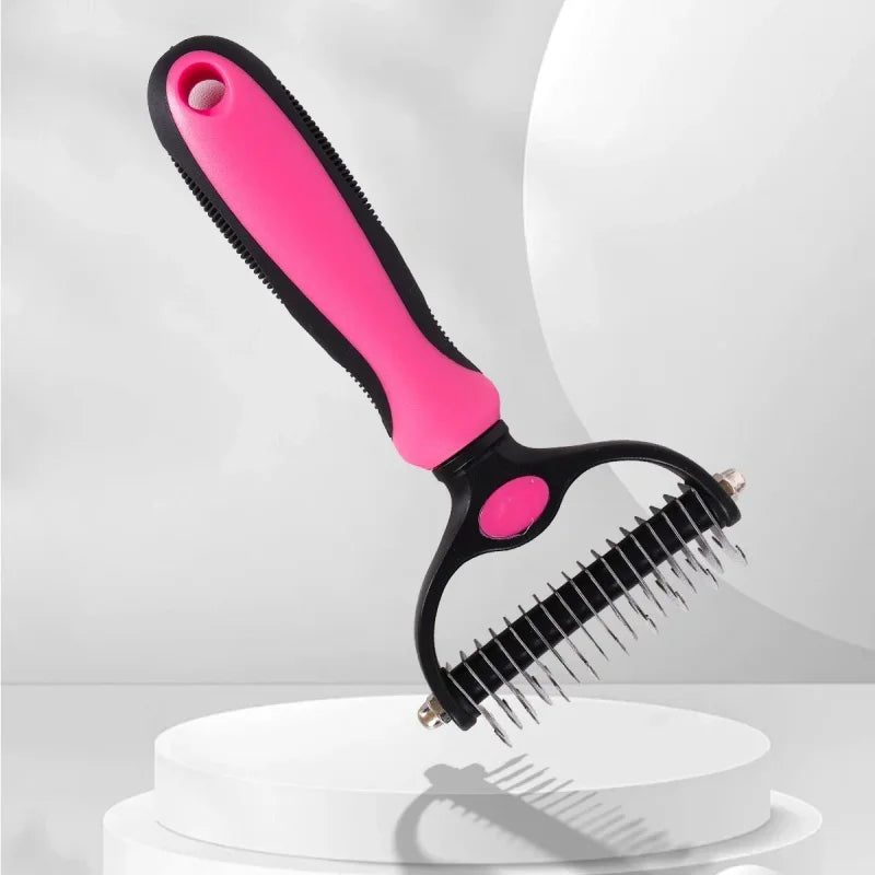 Pet grooming rake with a bright pink and black ergonomic handle and sharp metal teeth.