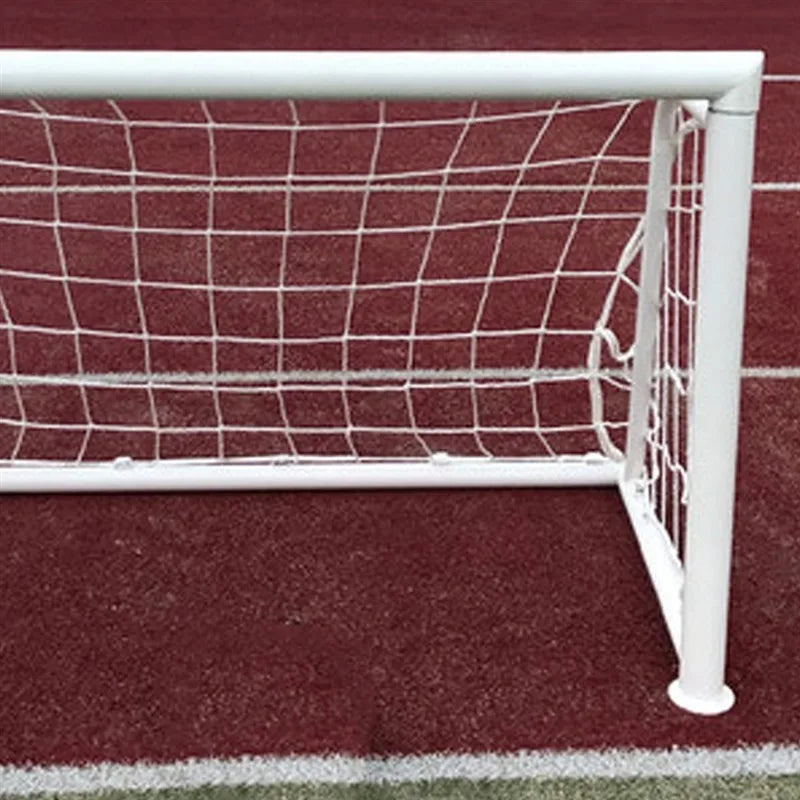 White football goal with a sturdy frame and white net, positioned on a red running track surface.