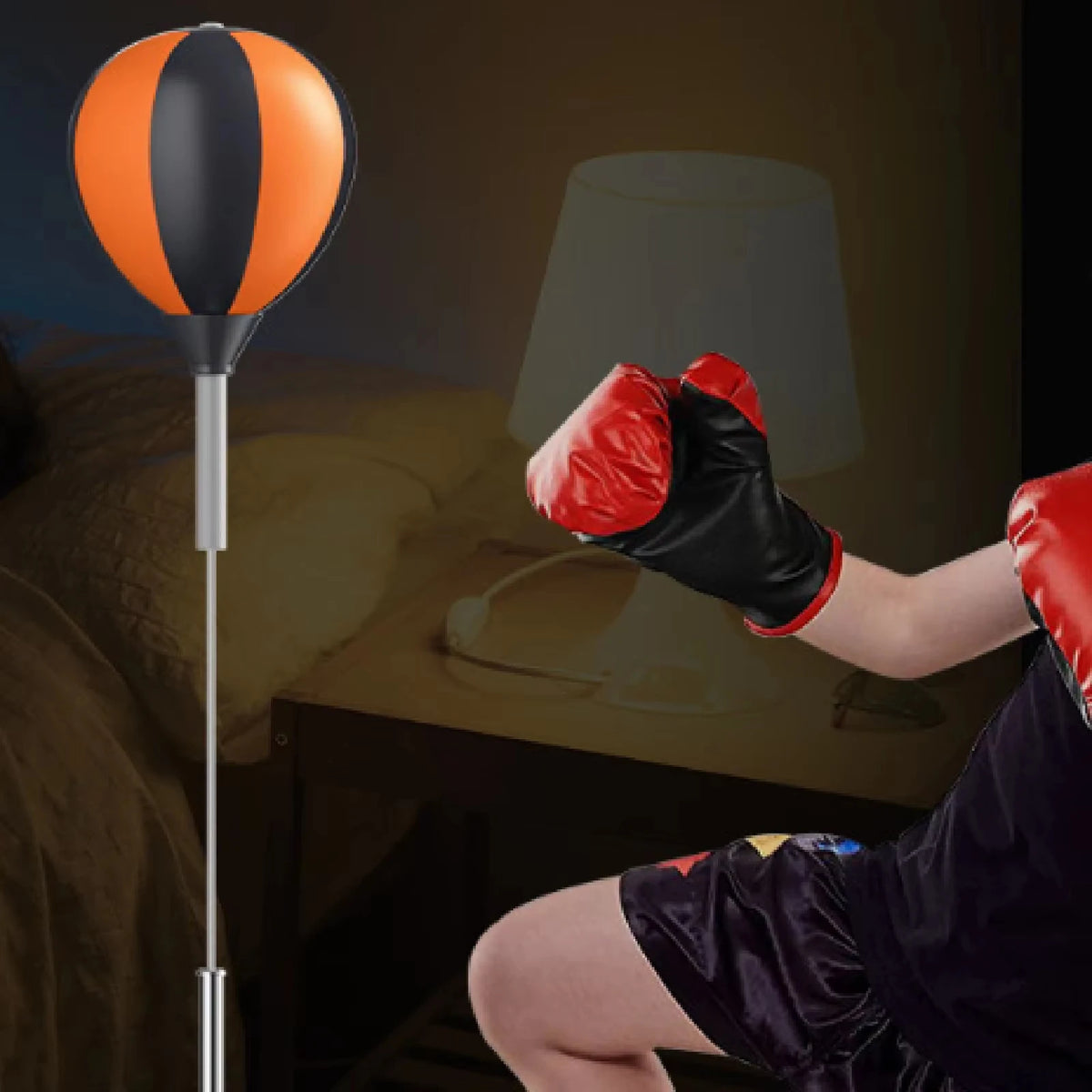 Orange and black height-adjustable speed bag on a stand with a child wearing red and black boxing gloves.