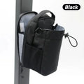Black drawstring bag with a grab handle, side pocket, and zip-open light grey interior, hanging on a post.