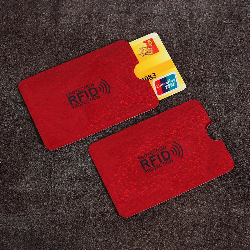 Two red, glittery RFID-blocking sleeves made of thin material, with one sleeve partially holding a bank card.