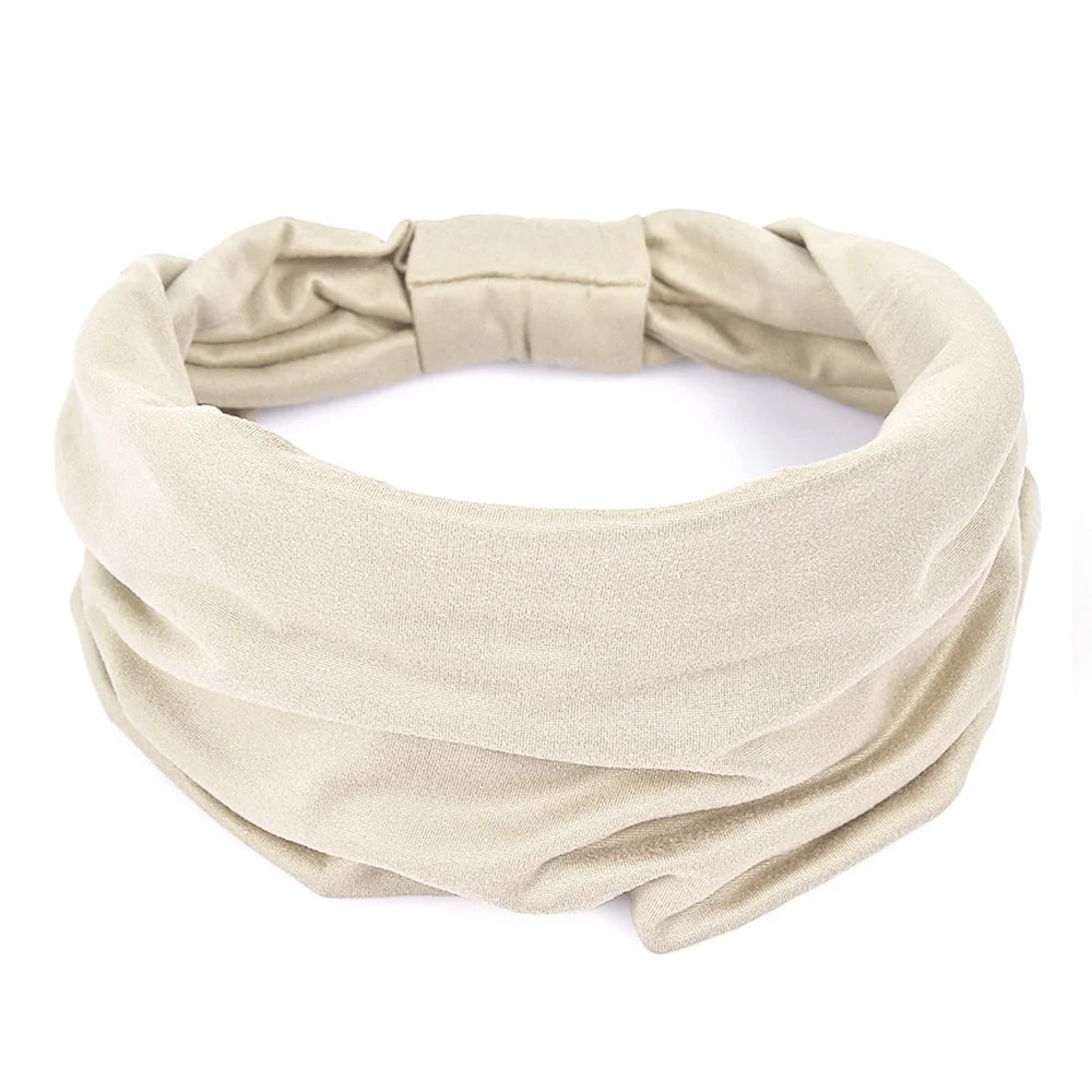 Beige fabric headband with a wide, ruched design and elasticated back, isolated on a white background.