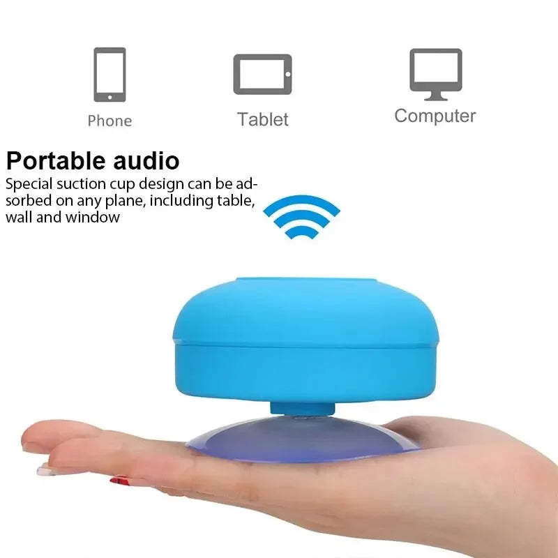 Bright blue portable Bluetooth speaker with a suction cup base, held in a hand. Suitable for phones, tablets and PCs.