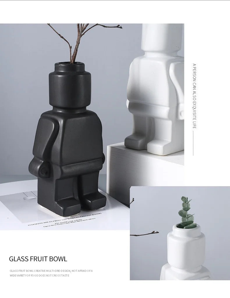 Matte black and white ceramic robot-shaped vases for home decor, perfect for small plants or decorative stems.