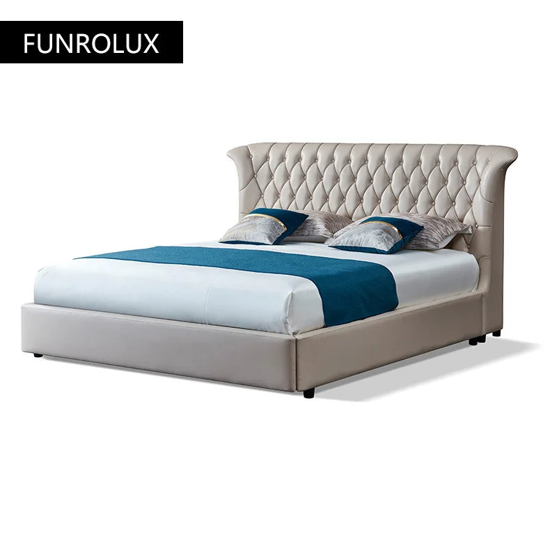 Luxury double bed in beige leather with a tufted, curved-wing headboard. Elegant, modern design on a white background.