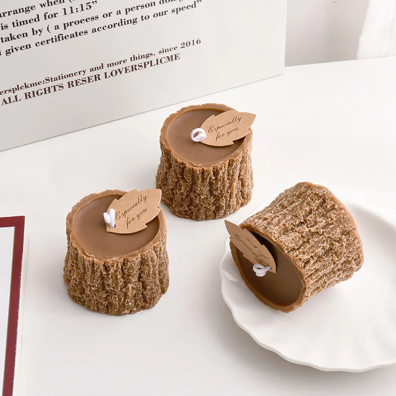 Three brown tree-stump shaped candles with textured bark detail and "Especially for you" leaf-shaped gift tags.