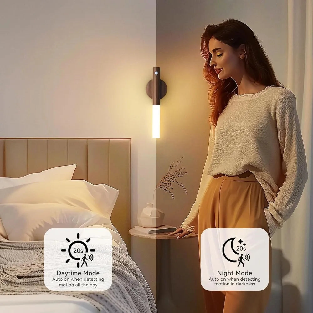 Minimalist dark wood motion sensor LED wall light emitting warm light in a bedroom, with day and night mode icons.