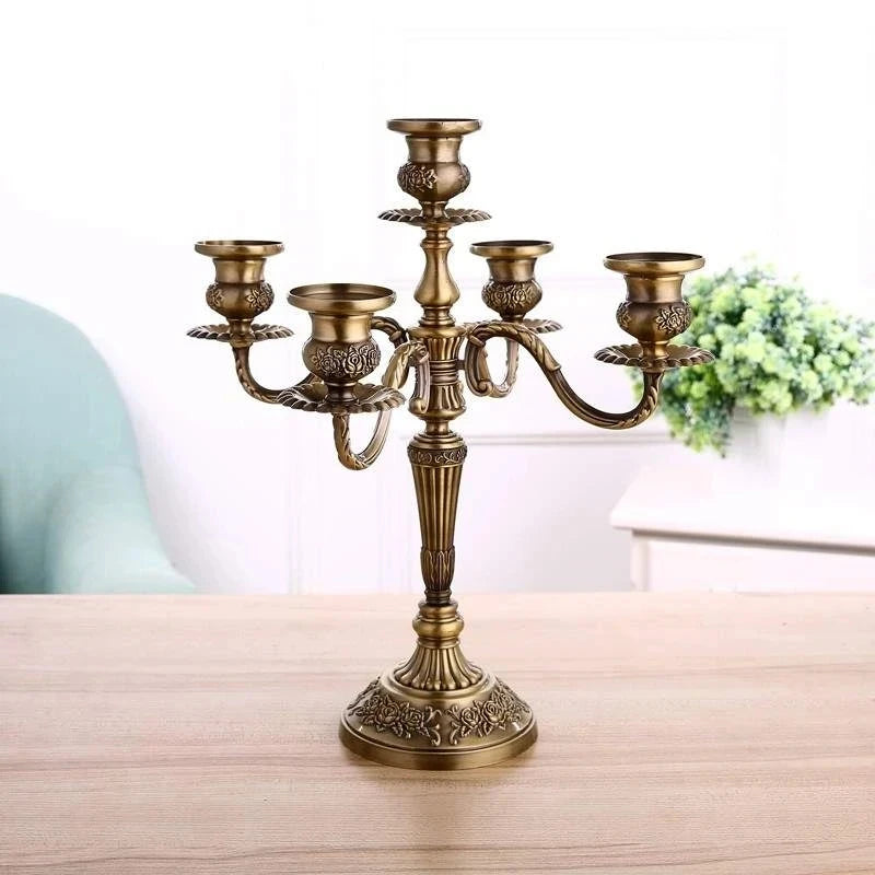 Bronze metal 5-arm candelabra with ornate floral embossed details on the base and candle cups.