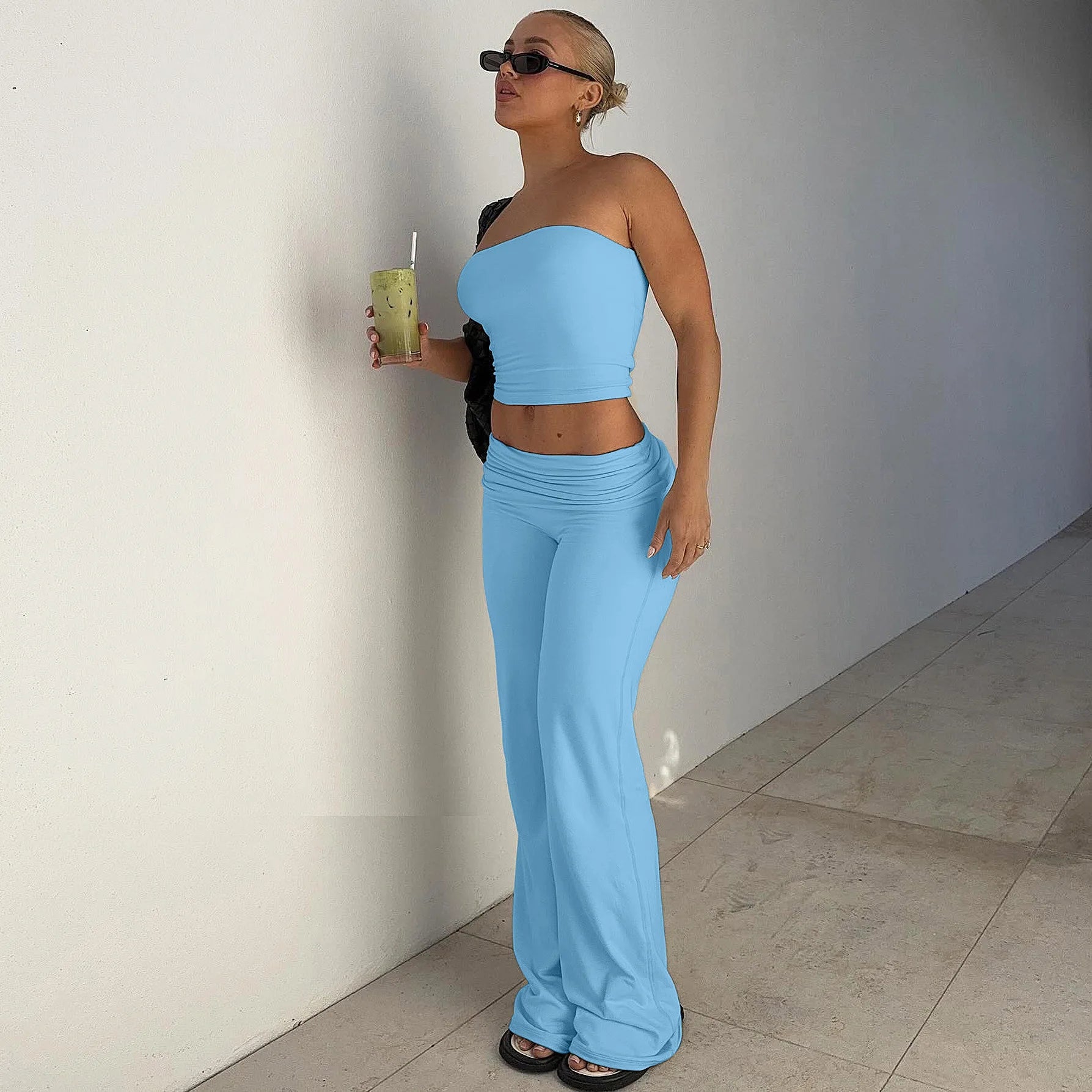 Model wearing a baby blue strapless crop top and matching low-rise flared trousers.
