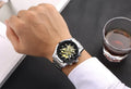 Men’s stainless steel automatic watch with a black tachymeter bezel and an intricate gold skeleton dial on the wrist.