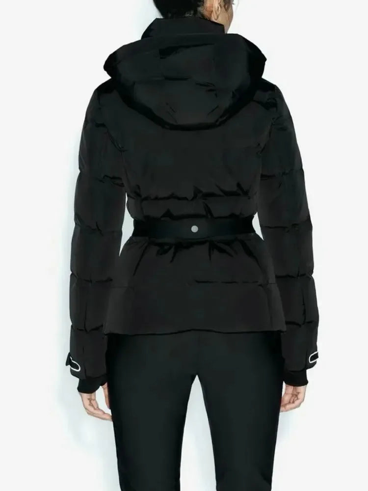 Back view of a black hooded quilted puffer jacket with a belted waist and fitted cuffs, worn over black trousers.