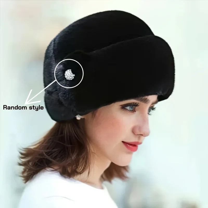 Elegant black faux fur winter hat with a decorative jewelled side detail, worn by a woman.