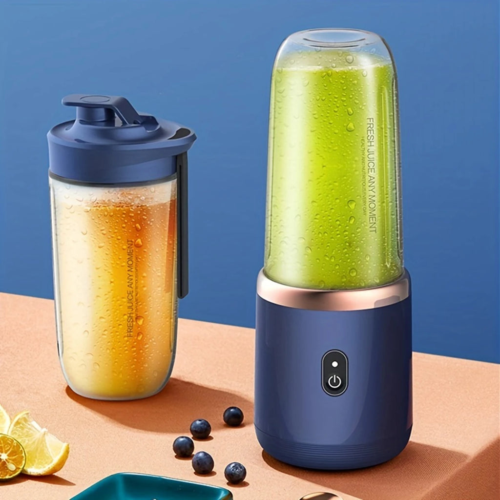 Two portable blue blenders on a table, one containing green juice and the other an orange beverage with fruit nearby.
