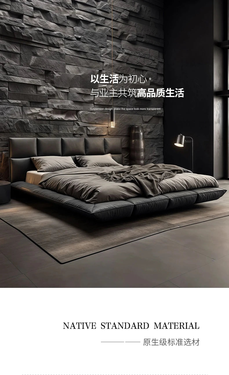 A modern, low-profile black leather king-size floating bed set against a grey stone feature wall.