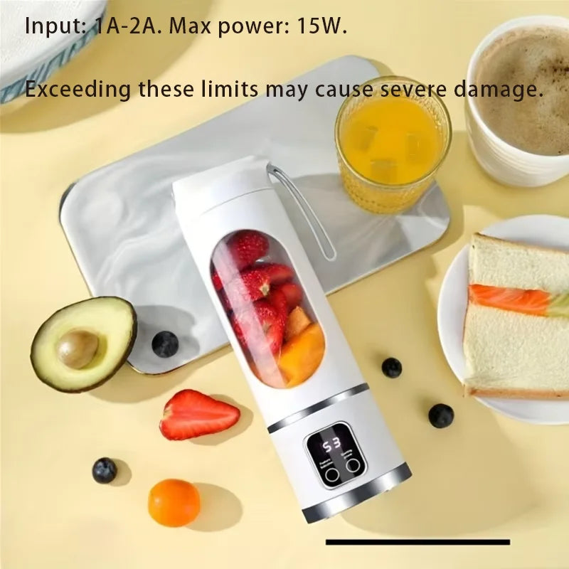 White portable blender with a digital display and clear fruit-filled blending chamber, on a yellow table with breakfast.