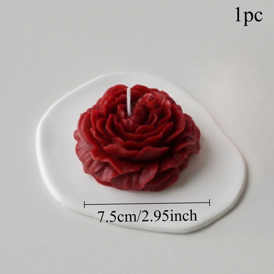 Deep red rose-shaped candle on a white, irregular-shaped decorative base. Measures approximately 7.5cm/2.95 inches.