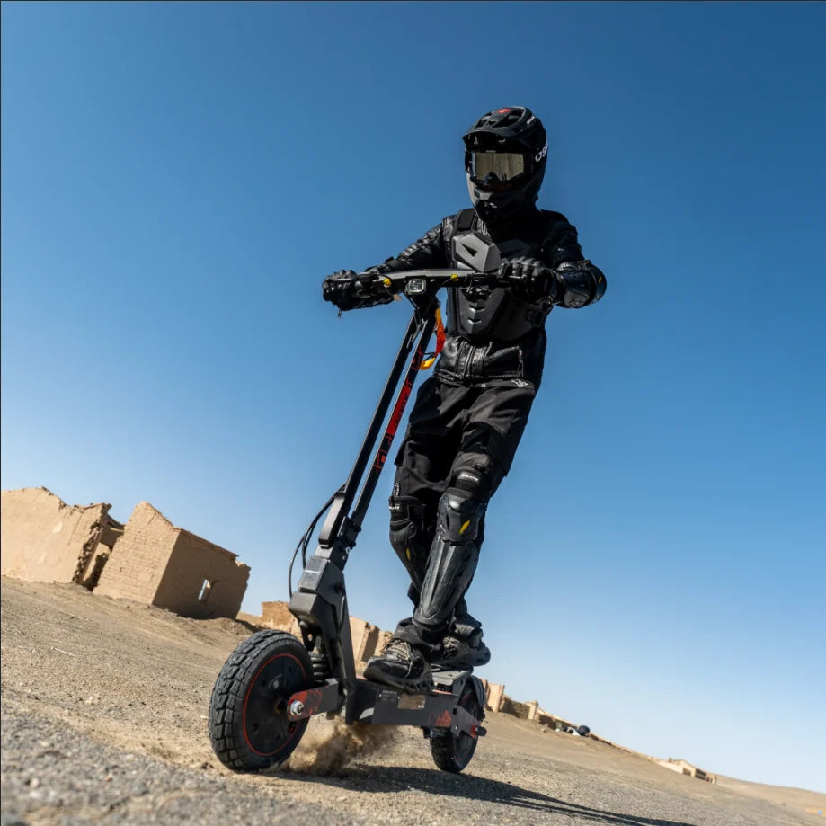 Black Kukirin G2 Ultra electric scooter with dual motors and 10-inch tires, ridden outdoors by a person in protective gear.