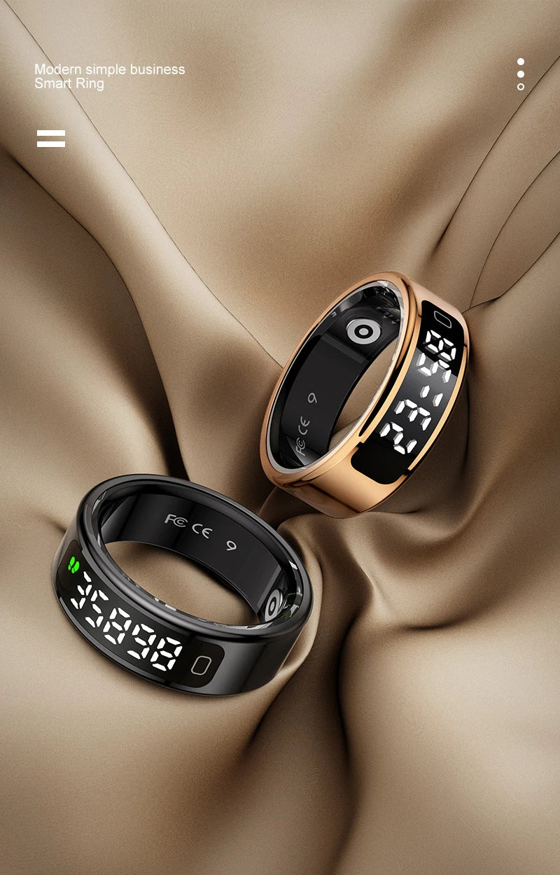 Two smart health monitoring rings in black and rose gold, featuring digital LED displays, resting on draped fabric.
