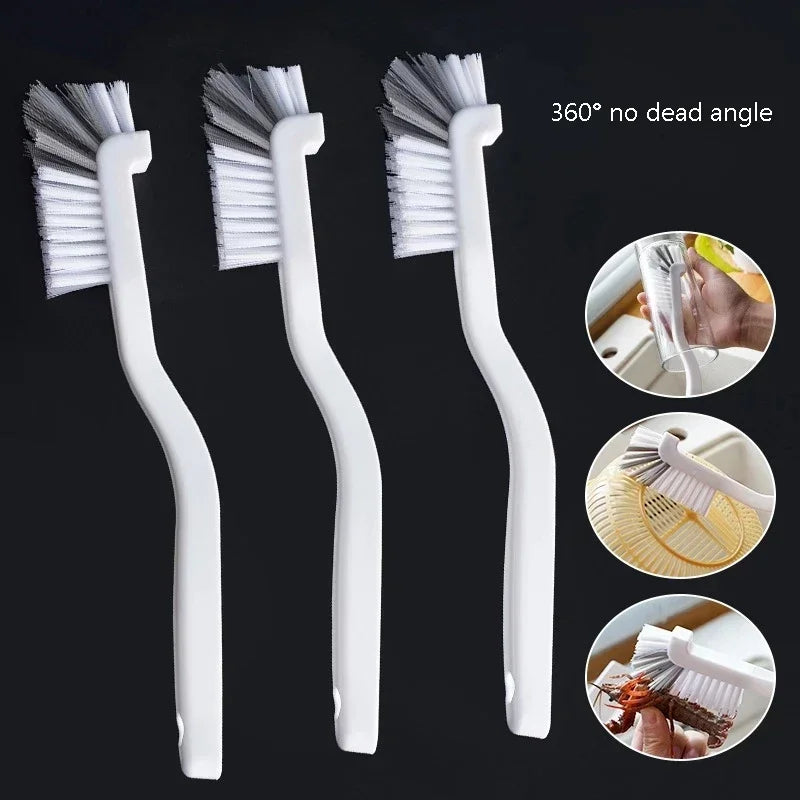 Set of three white, long-handled cleaning brushes with angled bristles for reaching tight corners and crevices.