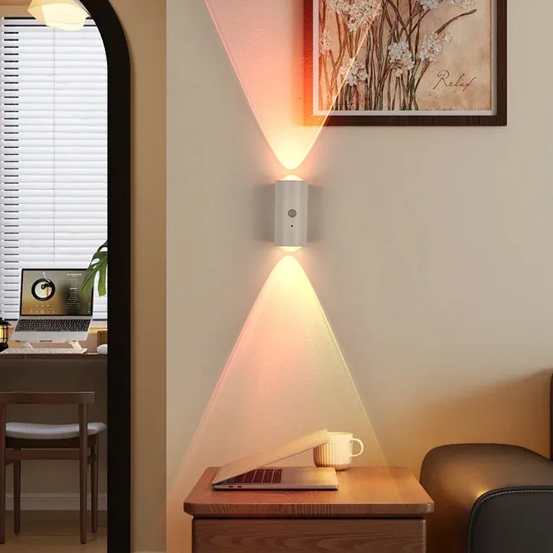 Minimalist white LED wall lamp casting a colourful up-and-down ambient light beam on a modern living room wall.