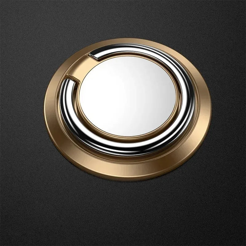 Round gold phone ring holder with a polished silver interior ring, set against a dark textured background.