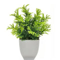 An artificial fern-like plant with vibrant green leaves in a smooth, minimalist matte white pot against a white background.