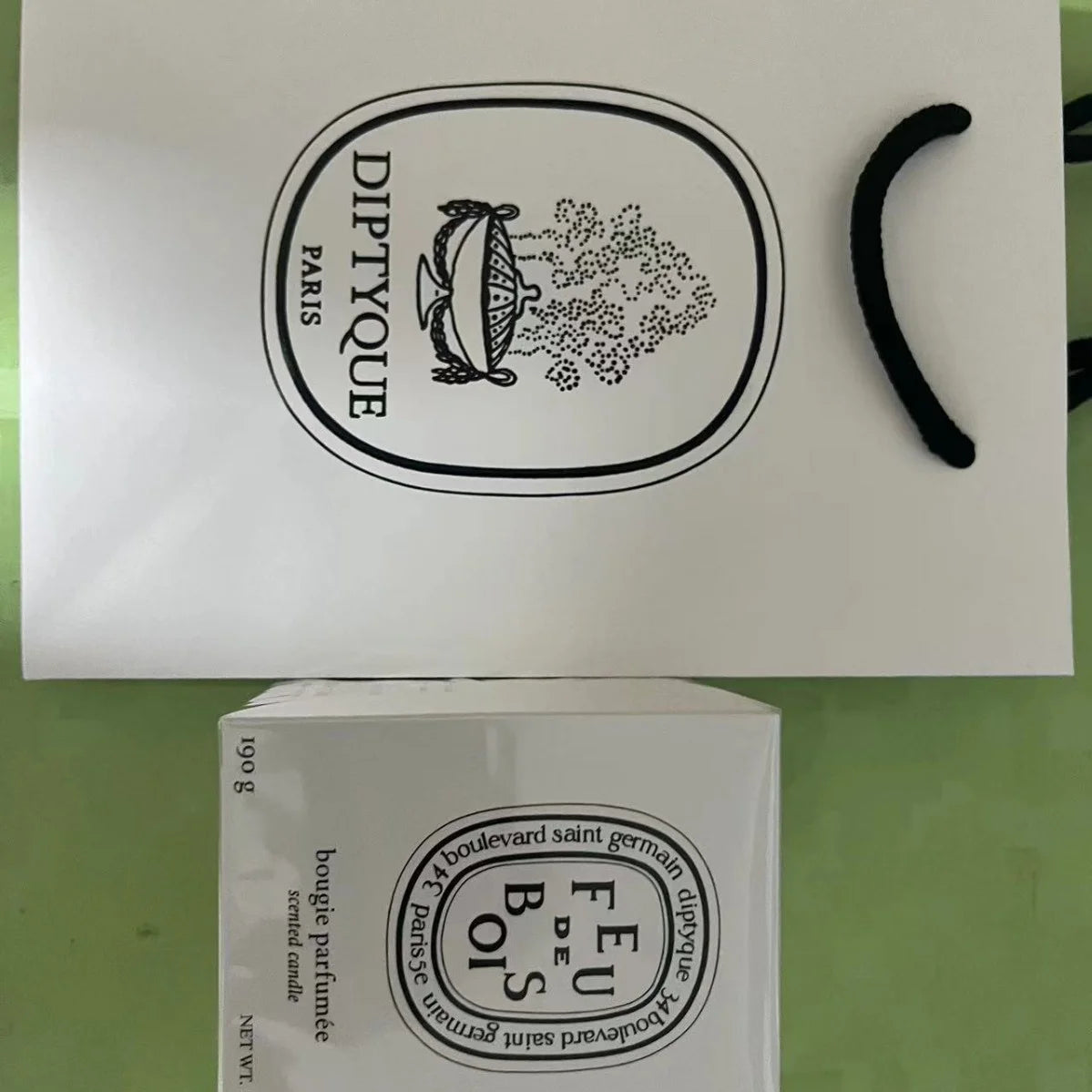 White 190g luxury scented candle box with matching branded white gift bag, featuring classic black typography.
